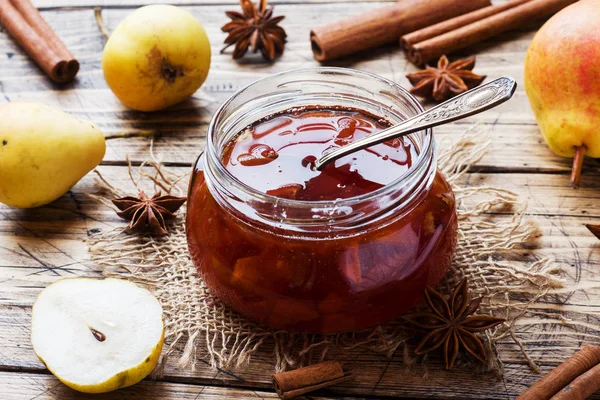 Mermelada de pera casera en un frasco y peras frescas sobre un fondo de madera. — Foto de Stock