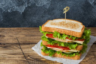 Koyu ahşap bir masada lezzetli ve taze sandviçler. Kopyalama alanı.