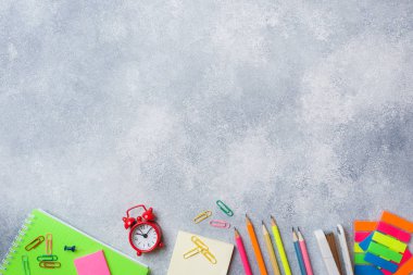 Okul malzemeleri, kopya alanı ile gri arka plan üzerinde defter kalemler.