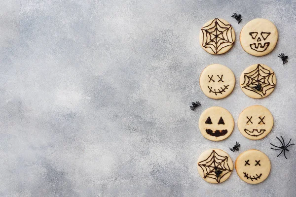 Homemade cookies for Halloween. Cookies with funny faces and spider webs. Copy space.
