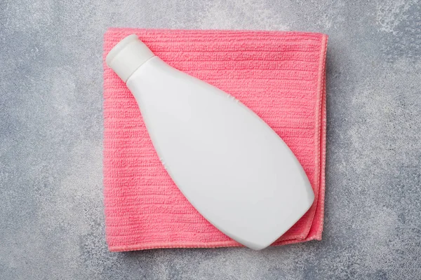 Botol plastik putih pada handuk merah muda. Aksesoris kamar mandi . — Stok Foto