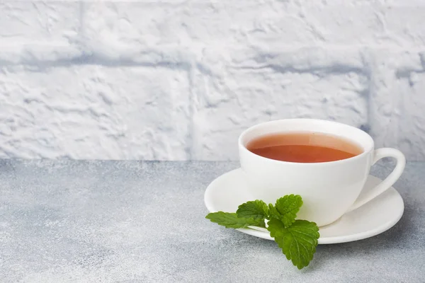Τσάι μέντας σε ένα λευκό Κύπελλο με φρέσκα φύλλα δυόσμου. Γκρι φόντο χώρος αντιγραφής. — Φωτογραφία Αρχείου