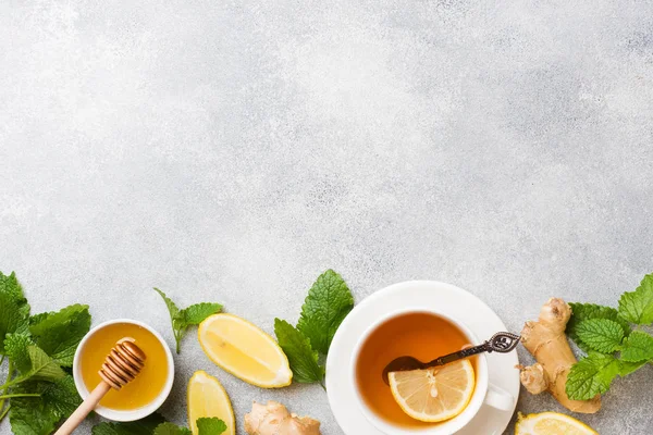 Weiße Tasse mit natürlichem Kräutertee Ingwer Zitronenminze und Honig. grauer Hintergrund Kopierraum. — Stockfoto
