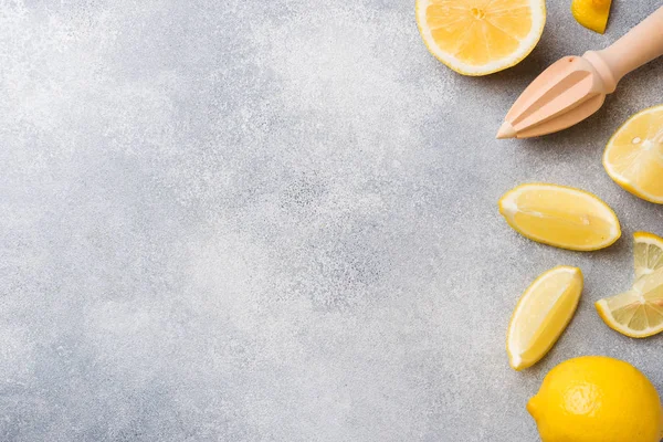 Reife Zitronen- und Zitronenscheiben auf grauem Hintergrund mit Kopierraum. — Stockfoto