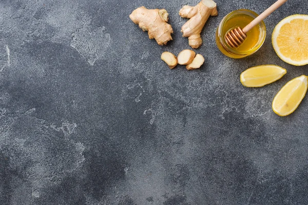 Zitronenhonig und Ingwerwurzel auf dunkelgrauem Hintergrund mit Kopierraum. Zutaten für ein stärkendes Vitamingetränk. — Stockfoto