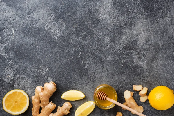 Лимонный мед и корень имбиря на темно-сером фоне с копировальным пространством. Ингредиенты для тонизирующего витаминного напитка . — стоковое фото