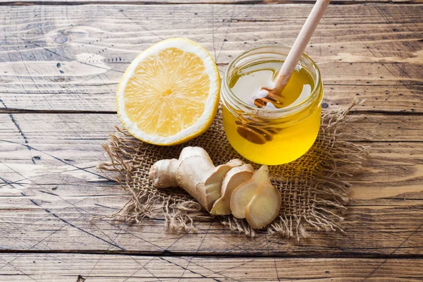 Lemon honey and ginger root on wooden background with copy space. Ingredients for a tonic vitamin drink. — Stock Photo, Image