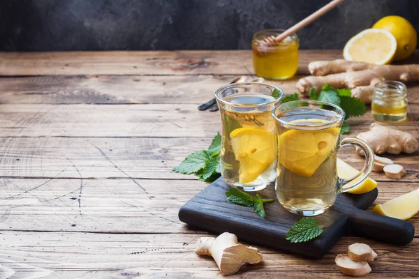 Zwei Tassen natürlichen Kräutertee Ingwer Zitronenminze und Honig auf einem hölzernen Hintergrund. Kopierraum — Stockfoto