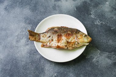 Bir plaka üzerinde pişmiş sazan balık. koyu arka plan. Kopya alanı.