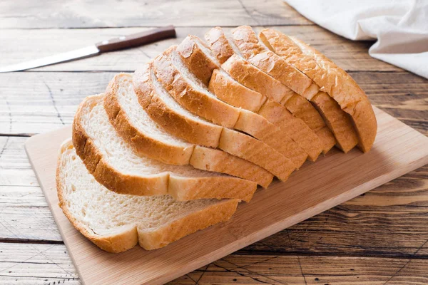 Kawałki białego chleba chleb na tosty na drewnianym stole. — Zdjęcie stockowe
