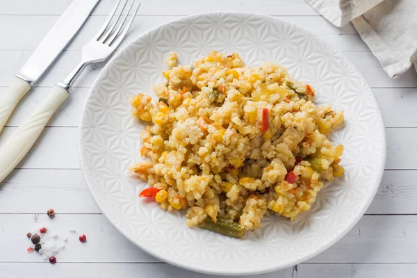 Pilaf con verduras y pollo en un plato gris sobre un fondo claro . — Foto de Stock