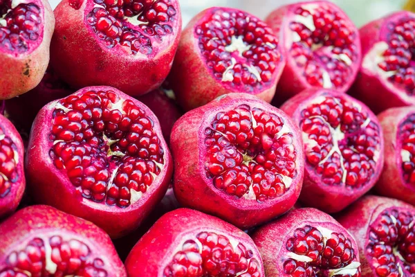 Background of fresh ripe pomegranates with incision on the counter in the street market. — Stock Photo, Image