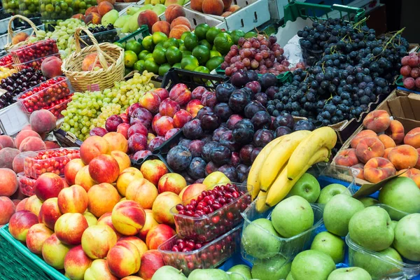 Fruits and vegetables on the counter of the street market. Bananas peaches nuts watermelon melon tomato apples grape plums. — Stock Photo, Image