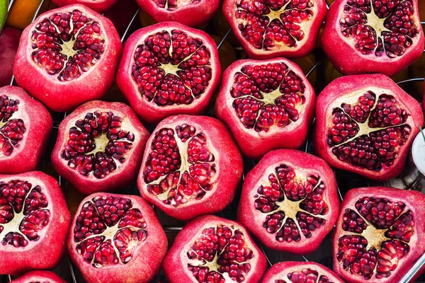 Background of fresh ripe pomegranates with incision on the counter in the street market. — Stock Photo, Image