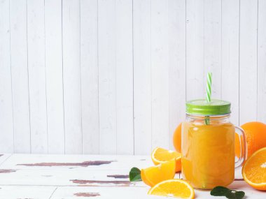 Beyaz ahşap r cam kavanoz ve taze portakal portakal suyu