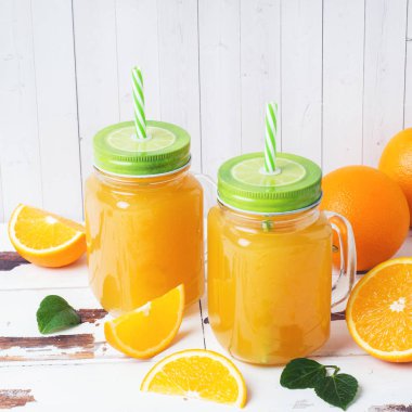 Beyaz ahşap r cam kavanoz ve taze portakal portakal suyu