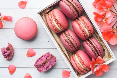 Pembe tatlı makarna veya beyaz bir arka plan üzerinde bir kutu içinde macaroons