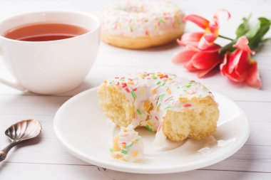 Çay ve çörekler Fincan, kopya alanı ile beyaz masada çiçek lale.