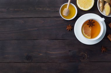 Doğal bitkisel çay zencefil limon ve bal tarçın ile Beyaz Fincan. Enerji vitamini içeceği soğuk algınlığı için kullanılır. Koyu ahşap arka plan kopyalama alanı