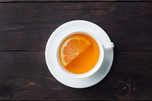 Белая чашка с натуральным травяным чаем с лимонной корицей. Горячий витаминный напиток используется для холодной.Тёмный деревянный фон пространство для копирования . — стоковое фото