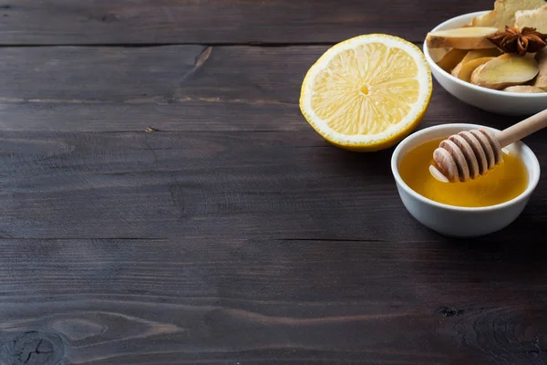 Лимонный жидкий мед и имбирь. Ингредиенты для напитка используются для охлаждения. . — стоковое фото