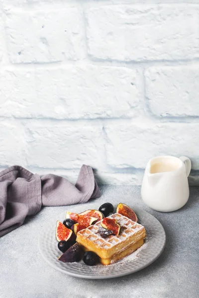 Waffles belgas tradicionais com uvas de açúcar em pó e figos. Café da manhã caseiro acolhedor. Fundo de concreto cinzento. Espaço de cópia . — Fotografia de Stock