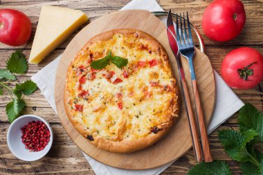 Ahşap arka planda domates ve peynirli ev yapımı pizza..