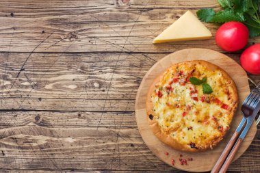 Ahşap arka planda domates ve peynirli ev yapımı pizza. Boşluğu kopyala