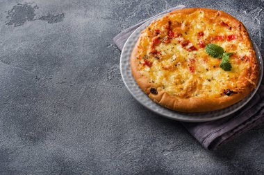 Gri beton arka planda domates ve peynirli ev yapımı pizza. Boşluğu kopyala