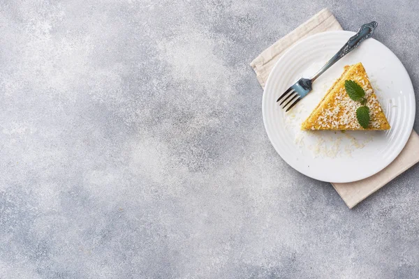 Un trozo de delicioso pastel de hojaldre con crema de mantequilla y mermelada de bayas en un plato con menta. Fondo de hormigón gris. Copiar espacio . — Foto de Stock