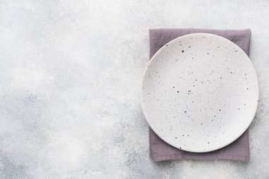 Açık beton arka planda boş seramik plaka. Üst görünüm.