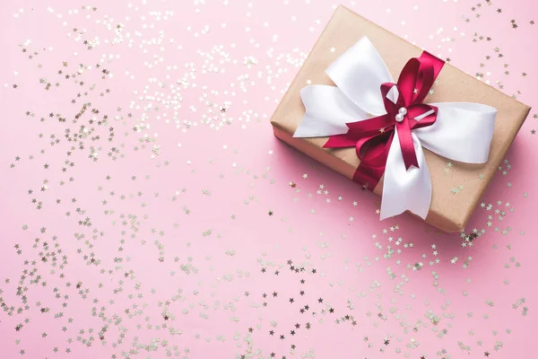 Hediye ya da hediye kutusu. Üstünde pembe masa manzarası olan büyük bir fiyonk. Noel için yassı beste, Anneler Günü ya da düğün.