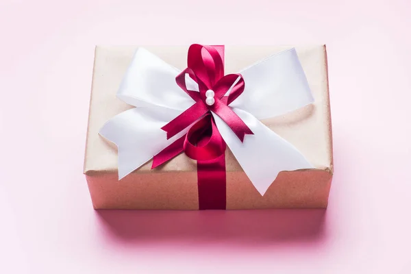 Coffret cadeau ou cadeau avec un grand noeud sur une table rose vue du dessus. Composition Flatlay pour l'anniversaire de Noël, la fête des mères ou le mariage . — Photo