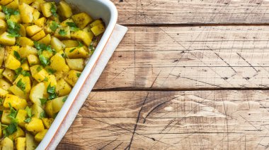 Seramik pişirme tepsisinde baharat ve otlarla pişirilmiş patatesler. V