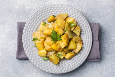 Baharat ve otlar bir plaka üzerinde fırında patates.