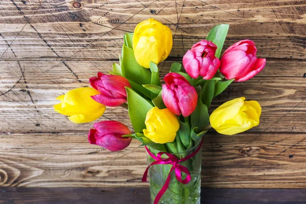 Ramo de tulipanes amarillos y rosados sobre fondo de madera . —  Fotos de Stock