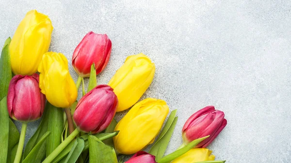 Ramo de tulipanes amarillos y rosados sobre un fondo azul claro. Co —  Fotos de Stock