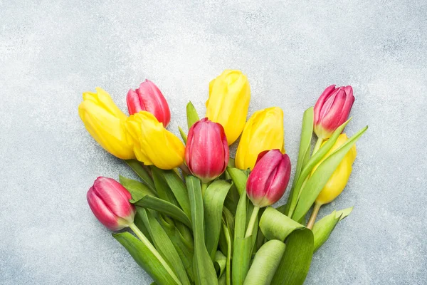 Ramo de tulipanes amarillos y rosados sobre un fondo azul claro. Copiar espacio —  Fotos de Stock