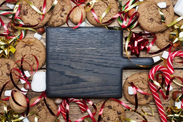 Biscoitos de chocolate Biscoitos de Natal bengalas caramelo vermelho cenário de ouro e marshmallow no fundo de madeira. Espaço de cópia Quadro . — Fotografia de Stock