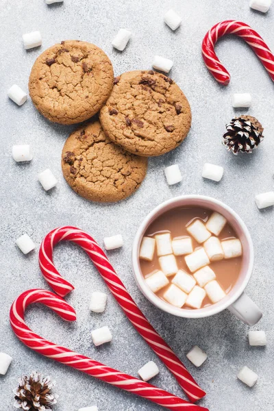 Il biscotto con gocce di cioccolato, la tazza di cioccolato caramello natalizio e i coni di marshmallow Decorazioni su sfondo grigio. Da vicino. — Foto Stock