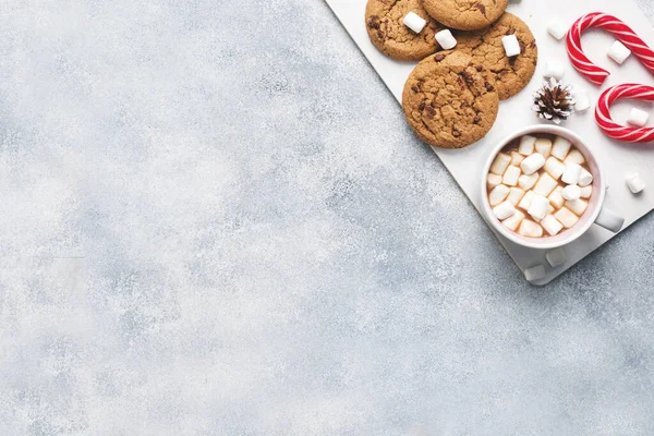 초콜릿 칩 쿠키, 크리스마스 사탕수수 캐러멜 컵 코코아, 마시멜로 콘 장식을 회색 배경으로 하고 있다. 복사 공간 프레임. — 스톡 사진