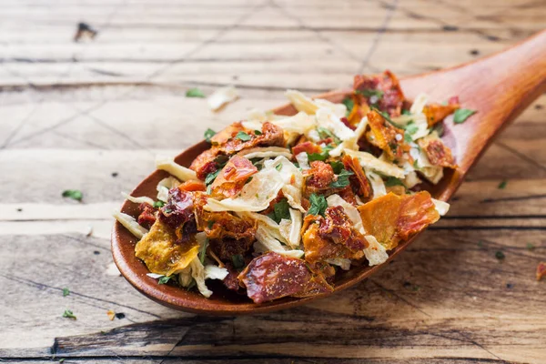 Dried spices, sun-dried tomatoes, dried carrots, Basil and Provencal herbs in a wooden spoon on a wooden table. Copy space.