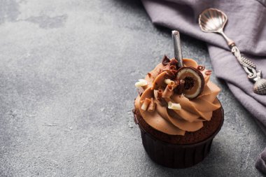 Çikolatalı kek, krema ve çikolata parçacıkları ile süslenmiş. Koyu beton arka plan. Boşluğu kopyala.