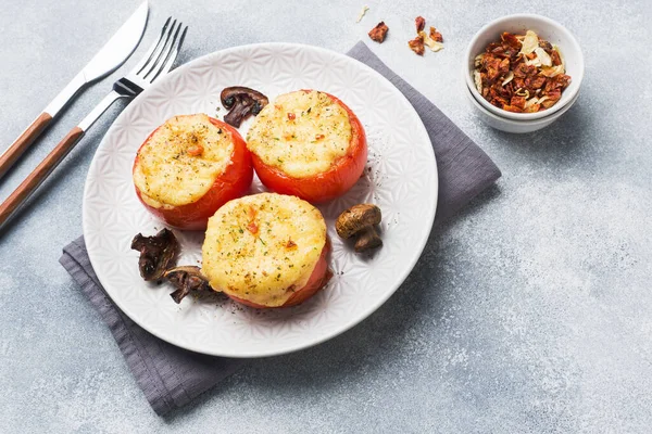 Tomates inteiros assados recheados de cogumelos e queijo com temperos em um fundo de concreto leve. Espaço de cópia . — Fotografia de Stock