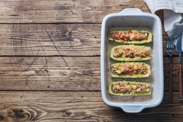Barche di zucchine ripiene al forno con funghi di pollo macinati e verdure con formaggio su una teglia da forno. Vista dall'alto Copia spazio — Foto Stock