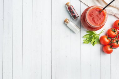 Kendi suyunda domates ya da cam kavanozda domates ve beyaz ahşap bir masada taze domates kopyala.