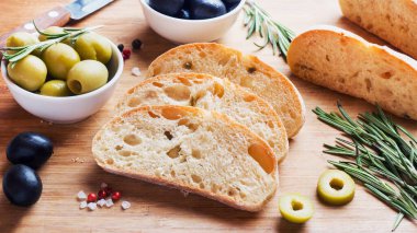 Ahşap bir Tahta üzerinde zeytin ve biberiye ile İtalyan ciabatta ekmek