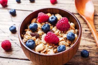 Sağlıklı kahvaltı. Taze granola, yoğurtlu müsli ve ahşap arka planda böğürtlen. Boşluğu kopyala.