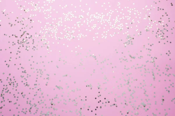 Confetti of gold stars glisten on a pink background. Festive holiday pastel backdrop. — Stock Photo, Image