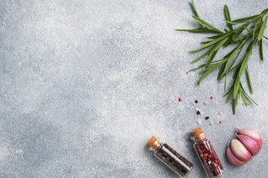 Gri arkaplanda yeşil biberiye ve sarımsaklı biber dalları..